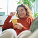 Woman laughs at a viral meme on her phone