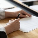 Person signing a piece of paper