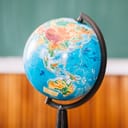 world globe positioned in a classroom with a blurred background