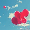 One balloon flying away from a bundle of balloons