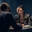 A blonde woman is being interrogated by the police after being found with a bag of drugs.