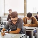 high school students taking an exam in a classroom