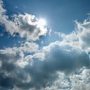 the sun peeking through clouds on the sky
