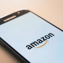 A phone on a desk with an Amazon logo on its screen