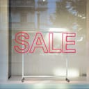 An empty store window with a SALE sign on it