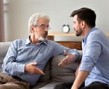 Two men having a conversation on the couch