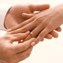 Man putting engagement ring on woman's finger, closeup