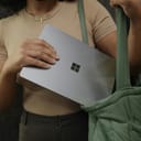 A female putting her laptop in her bag.