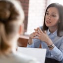 close-up of a determined businesswoman addressing clients during negotiations about project deadlines