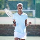 portrait of a young female tennis player celebrating her victory on the court