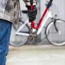 Thief in black gloves with pliers attempting to steal a bicycle