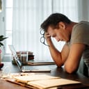 A stressed man looking at his laptop