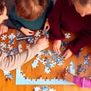 family at home doing a jigsaw puzzle together