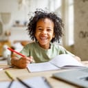 A smiling child doing homework at their home