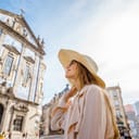 A young female tourist stands near the Congregados Church, adorned with Portugal's famous blue tiles.