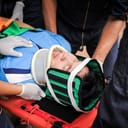 Injured man being carried on a stretcher by EMTs