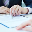 close-up of a businessman discussing contract terms with a business partner and showing him something with his pen