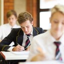 high school students sitting in classroom in uniforms