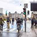 group of people on bicycles passing a green light