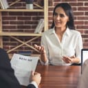 Woman being interviewed as interviewer reads her resume