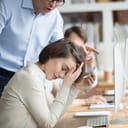 Irritated boss reprimanding a young woman employee