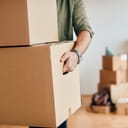 A person taking boxes out of the apartment
