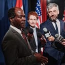 A politician giving an interview at a conference.
