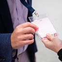 Man shows his visitor pass to enter an event