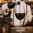 Bartender pouring red wine into a glass
