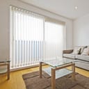 A large window with vertical blinds in a living room