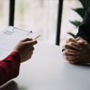 Close-up view of an employer reviewing a resume at a job interview in an office
