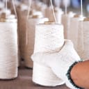 Yarn of cotton being held by a person wearing cotton gloves