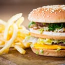 Hamburger and fries on a wooden plate