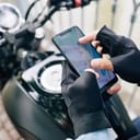 Motorcyclist using smartphone to zoom in on a map
