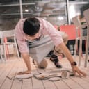 Waiter kneeling down to pick up scattered items from the floor inside a cafe