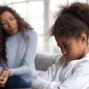 A child sulking while mother scolds her