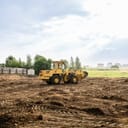 large yellow wheel loader leveling land for a new construction project on a building site