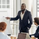man presenting an upward graph to colleagues