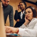 Three coworkers worriedly looking at a computer monitor