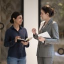 Two businesswomen talking with each other in the office hallway