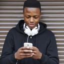 A teenage boy writing a message on his phone