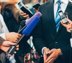 Man in suit talking to the press