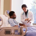 Doctor providing an explanation on tablet to a patient in bed