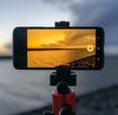 Phone camera on a pod capturing a photo of water surface