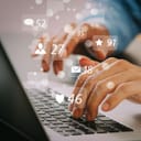 Person typing on laptop with social media notifications superimposed digitally