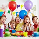 Kids celebrating at a birthday party with balloons and colorful cups.