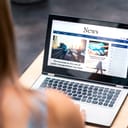 A woman reading news on her laptop