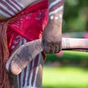 Close-up of a human hand grasping boomerangs during a ritual at an indigenous Australian Aboriginal community event.