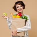 Smiling woman holding a bag of fruit and vegetables