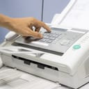 Person pressing buttons on a fax machine